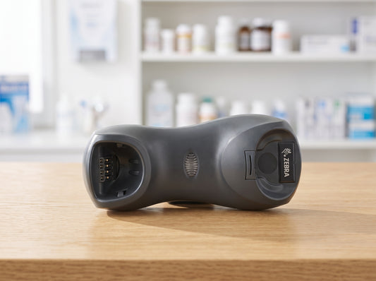 Zebra CR0078 standard base charging and communication cradle in Twilight Black, shown empty on a light oak service counter — cradle only, scanner not included