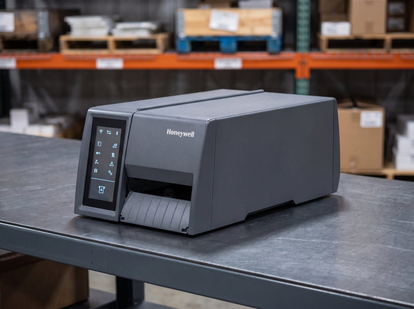 Honeywell PM45c compact industrial label printer with icon display on a packing bench in a distribution centre