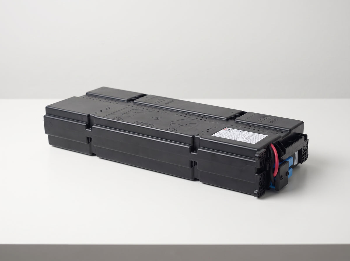 APC APCRBC155 replacement battery cartridge on a white service bench, black moulded case with blue connector — AI-generated image