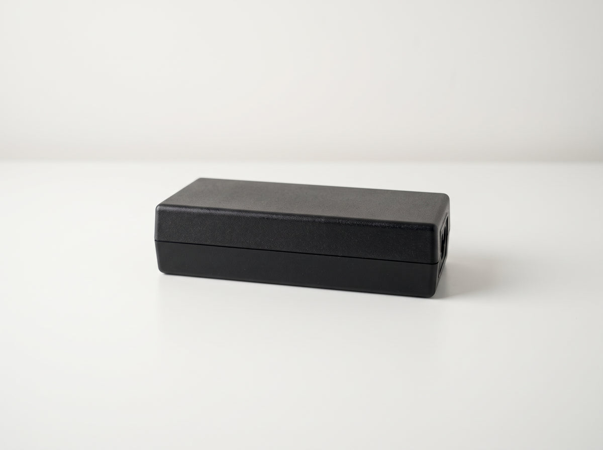 Epson A471H AC power adapter, black brick lying flat on a white desk — AI-generated image