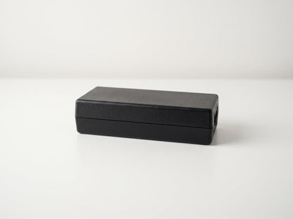 Epson A471H AC power adapter, black brick lying flat on a white desk — AI-generated image