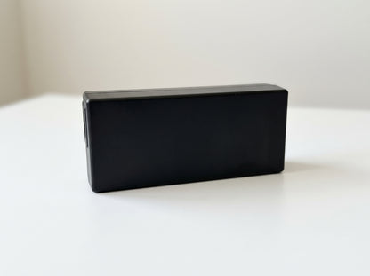 Epson A471H AC power adapter in black, side view on a white desk — AI-generated image