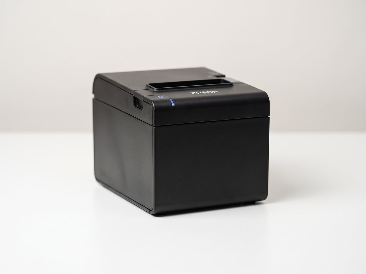 Epson OmniLink TM-m30II cube receipt printer in black, front three-quarter view on a white desk — AI-generated image