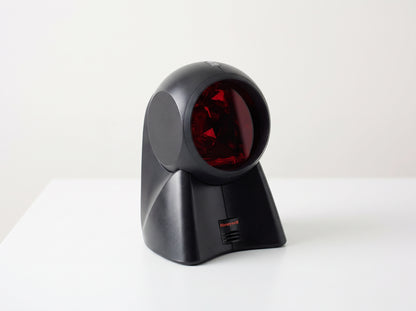 Honeywell Orbit 7120 omnidirectional presentation laser scanner in black on a cafe counter — AI-generated image