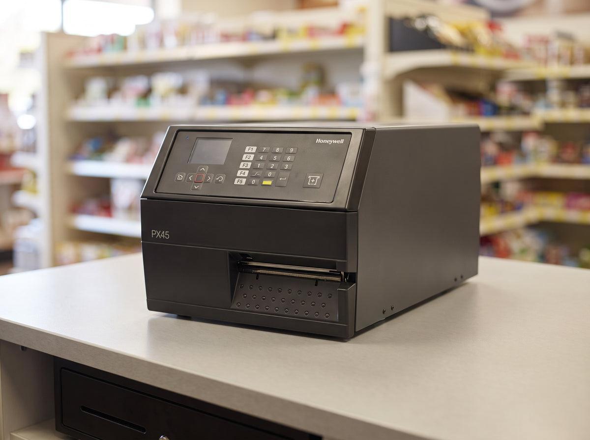 Honeywell PX45 high-performance industrial label printer in dark grey in a pharmacy dispensary — AI-generated image