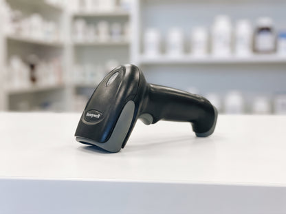 Honeywell Voyager XP 1472g cordless barcode scanner resting on a pharmacy counter — AI-generated image
