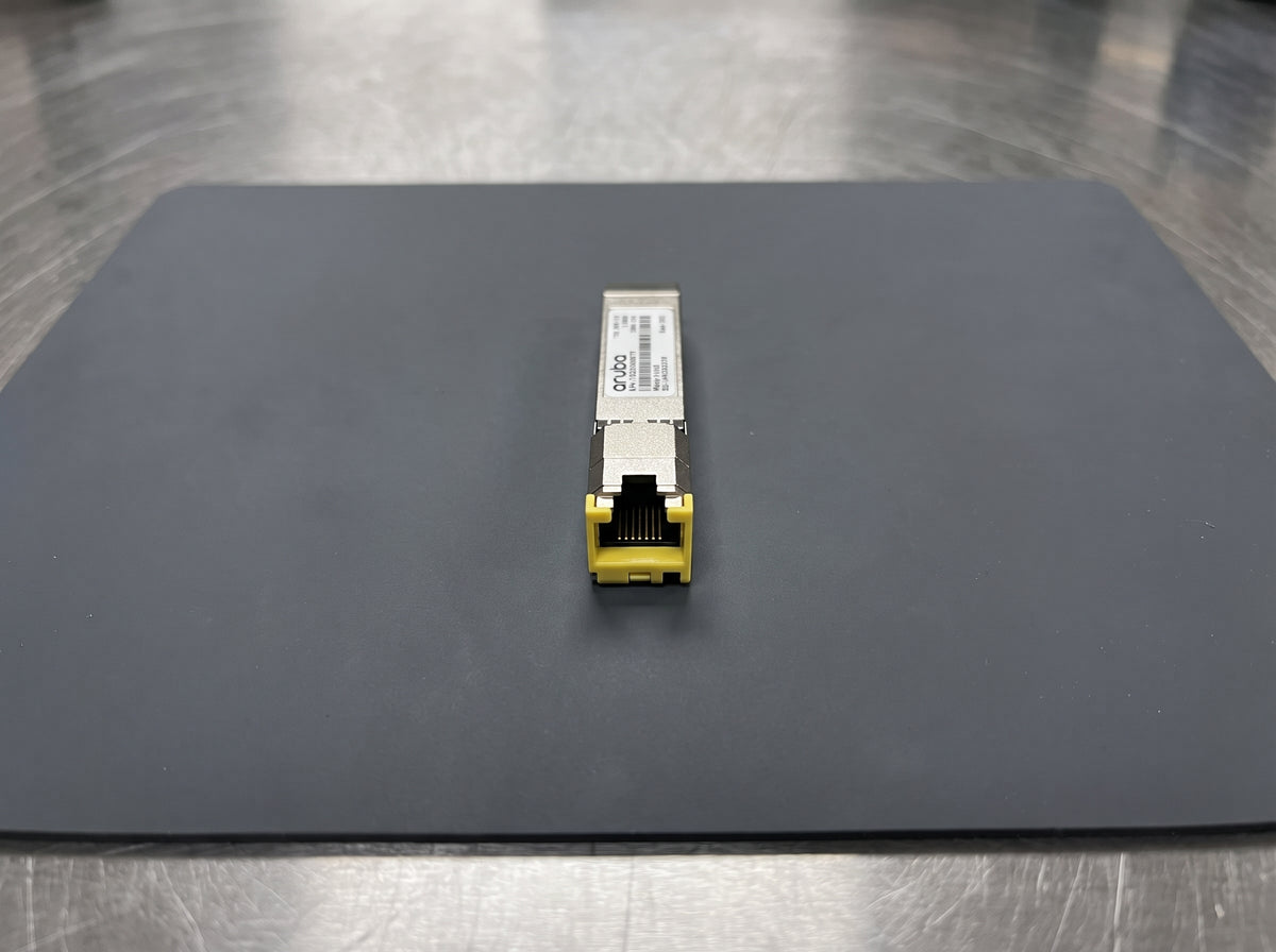 HPE Aruba 10GBASE-T SFP+ transceiver on an antistatic mat, RJ45 port toward the camera  — AI-generated image