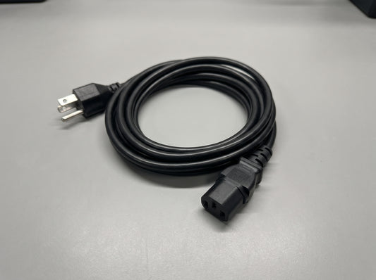 Zebra grounded AC line cord coiled on a bench, NEMA 5-15P plug and IEC connector — AI-generated image