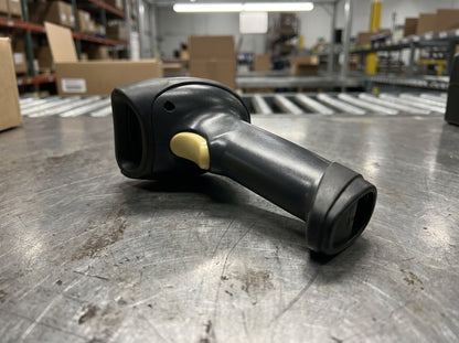 Zebra LS2208 corded laser barcode scanner in black on a steel workbench, scanner only — AI-generated image