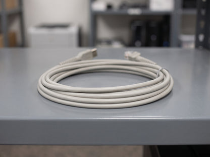 Zebra CBA-U01 light grey straight USB Series A scanner cable coiled on a store room shelf — AI-generated image