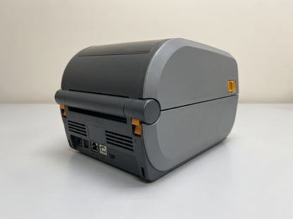 Zebra ZD411 2-inch direct thermal desktop label printer, rear panel showing the USB and Ethernet ports — AI-generated image